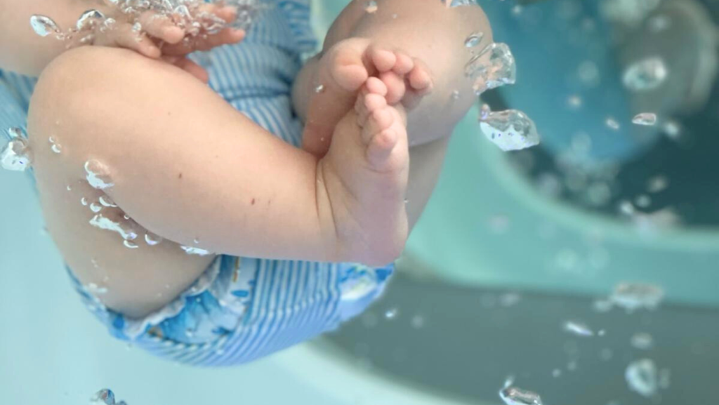 Nourrisson dans un bain à la baby spa Hauméa, bain relaxant pour bébé avec massage aquatique et jeu d'eau, soin bébé détente et bien-être global.
