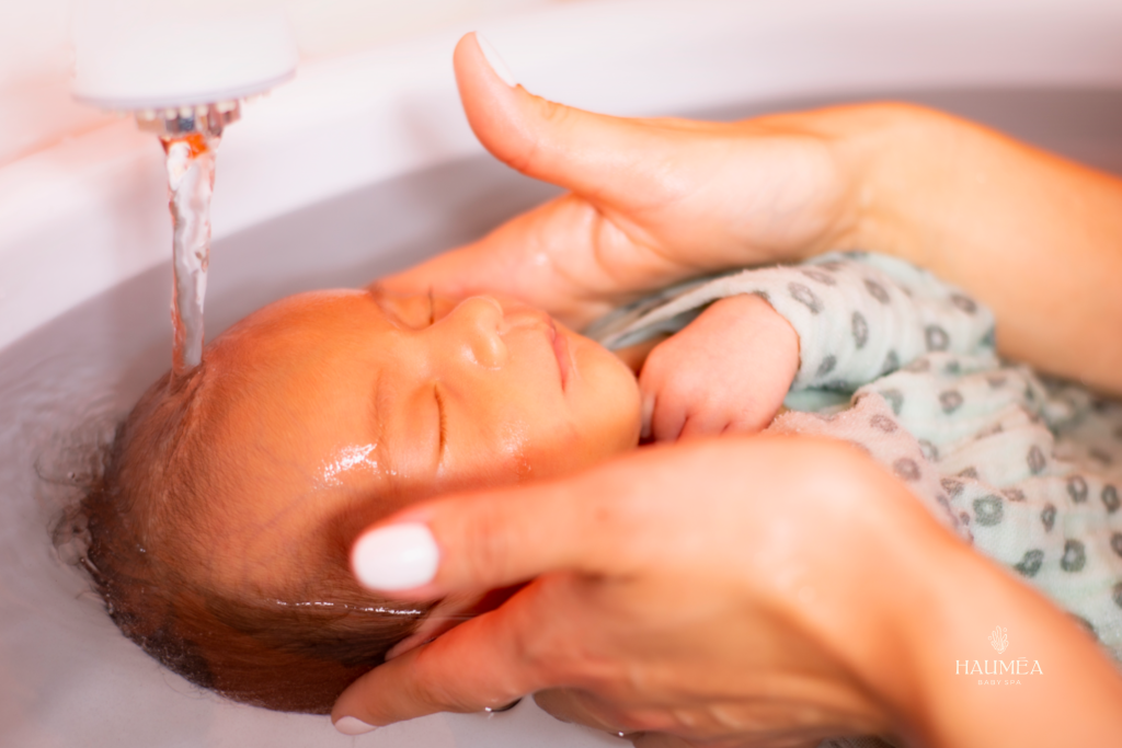 Douce baignade de bébé dans un spa spécialisé, mains d'une mère soutenant délicatement l'enfant, baignoire pour bébé, spa bébé, relaxation et bien-être pour nouveau-nés.