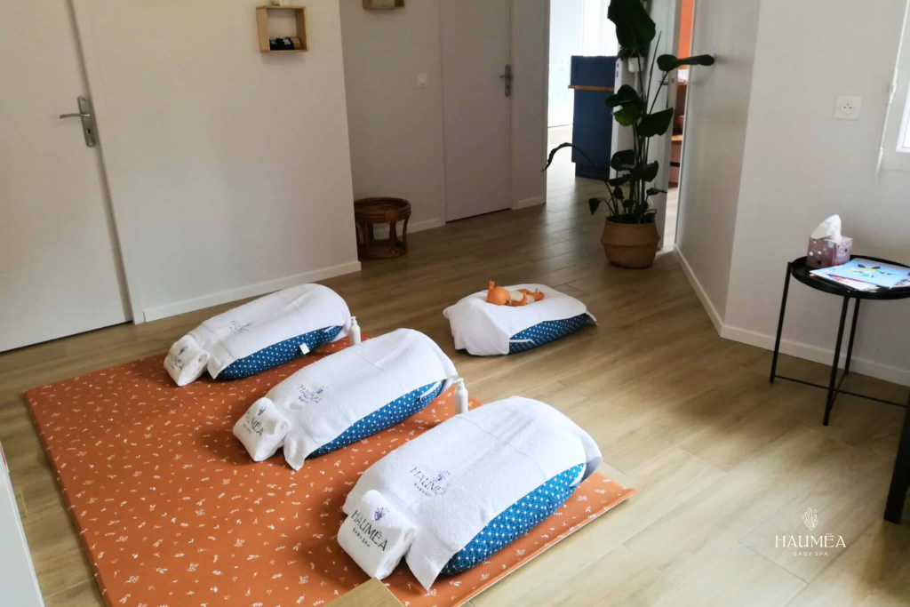 Véritable ambiance de spa pour bébé avec serviettes et coussins de massage Hauméa Baby Spa, espace chaleureux et relaxant pour soins et bien-être infantile transformation spa bébé à domicile en centre de détente et soins parent-enfant image adorable et apaisante de la zone de relaxation bébé, intérieur moderne et accueillant, conçu pour le confort et la sécurité des tout-petits espace dédié au spa bébé avec décoration minimaliste, lumières douces et ambiance zen, favorisant la détente et le calme des bébés en soins.