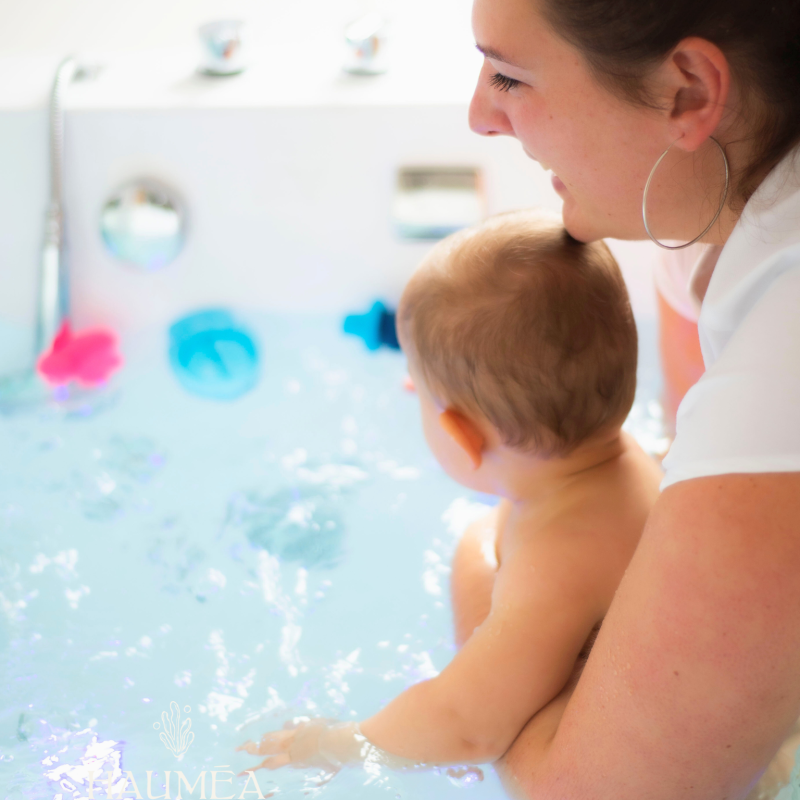 Enfant bébé dans un spa pour bébé, relaxation et soins aquatiques, avec une professionnelle, ambiance apaisante et ludique, soins bébé, bien-être enfants, spa bébé naturel et sécurisé.