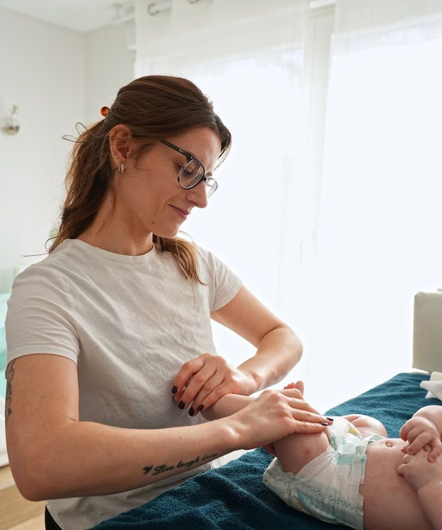 Massage des jambes d'un bébé sur la table de soin