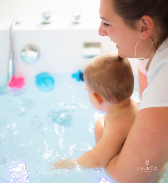 Une praticienne Hauméa accompagne un bébé dans le bain d'hydrothérapie